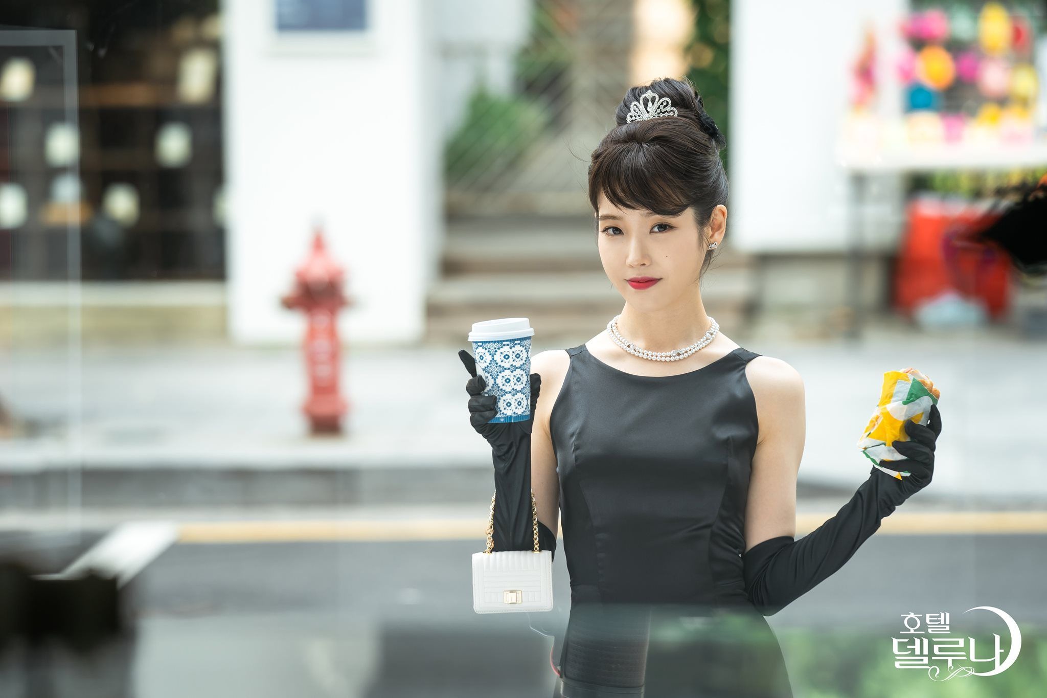IU mặc đầm đen, mang găng tay, đeo vòng cổ ngọc trai trong phim Hàn Quốc Hotel Del Luna