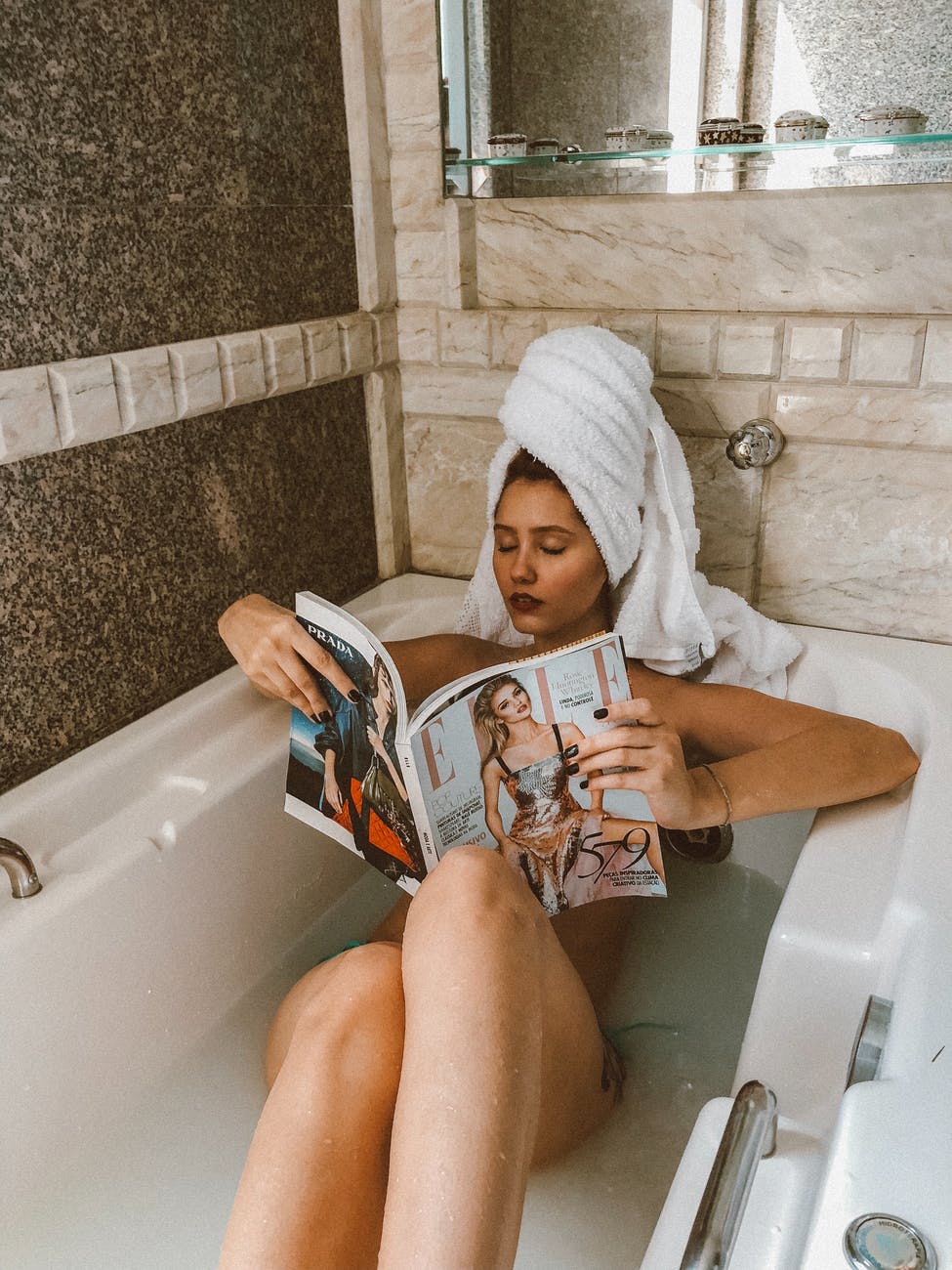 Tóc xù-Cô gái ngồi đọc tạp chí trong bồn tắm.