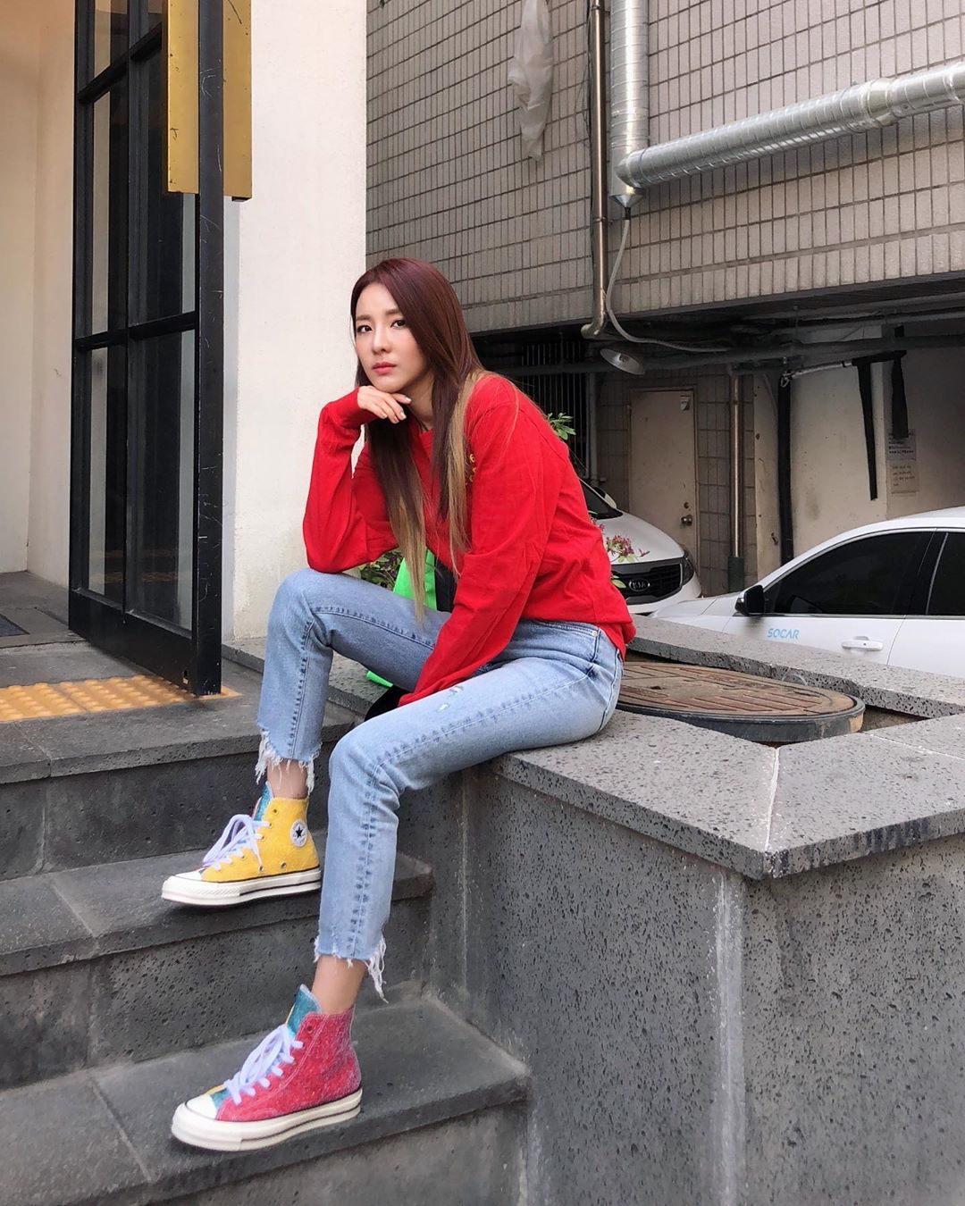 Sao Hàn Dara mặc áo đỏ, quần jeans, mang giày Converse màu đỏ và vàng