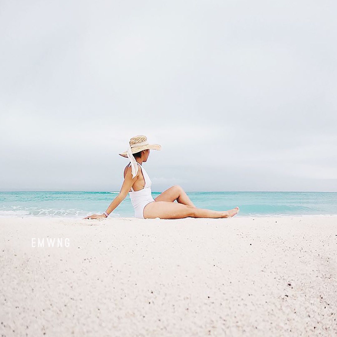 minimal aesthetic cô gái mặc đồ bơi ngồi trên bãi cát