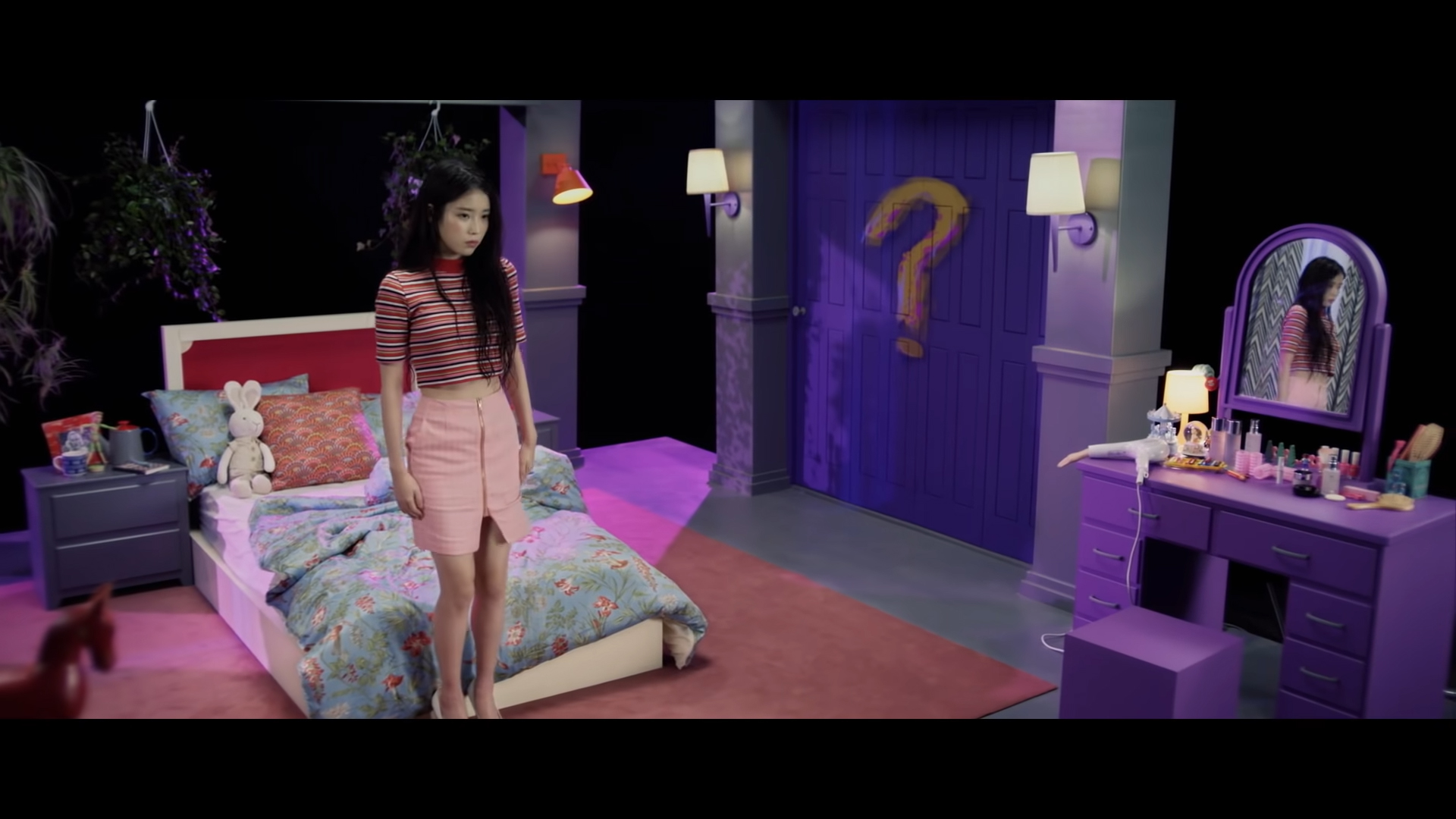 Ca sĩ IU mặc áo thun kẻ sọc và chân váy bút chì màu hồng trong MV 23