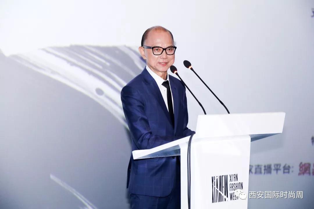 Prof. Jimmy Choo, OBE mặc âu phục xanh, phát biểu tại một sự kiện