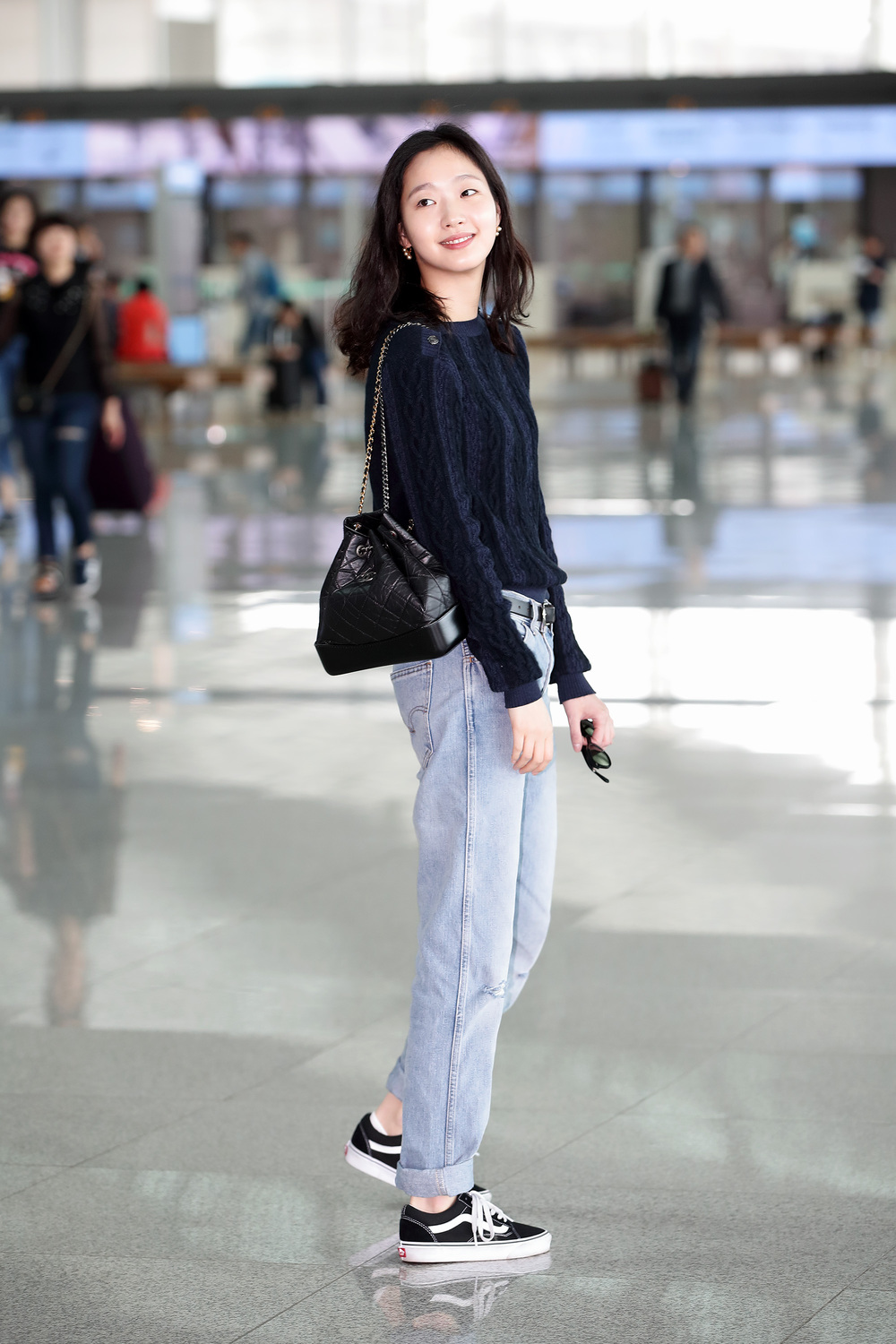 Kim Go Eun mặc áo len đen, quần jeans, giày Vans đen, túi Chanel