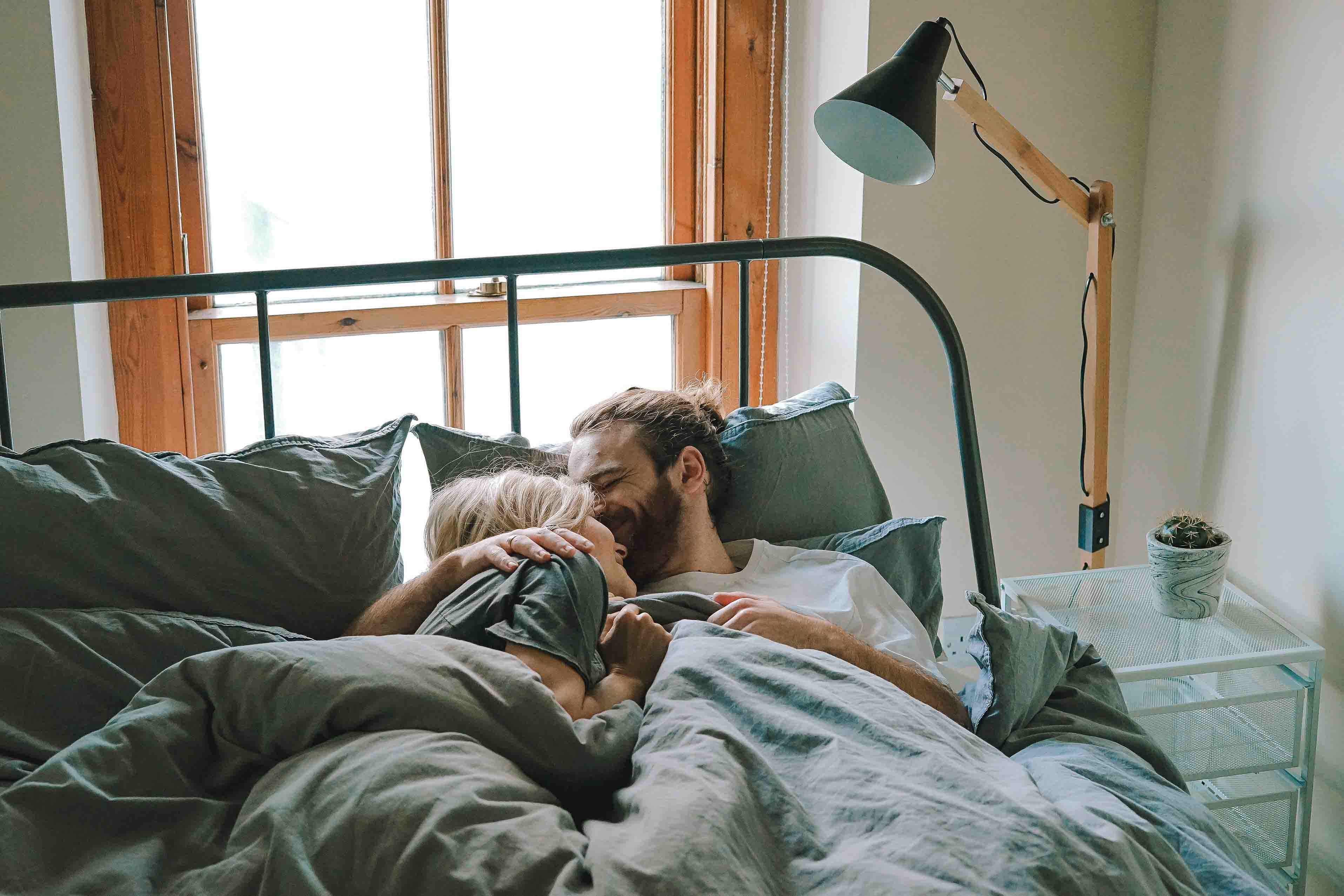 cặp đôi ôm nhau trên giường thể hiện tình yêu