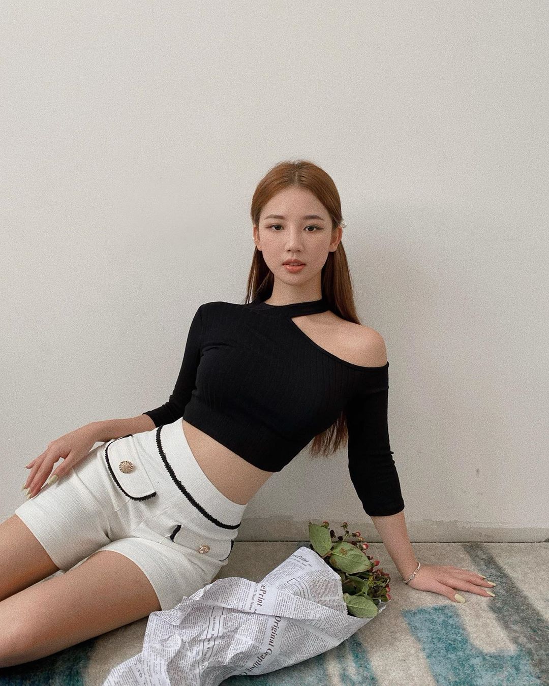 amee mặc áo crop top lệch vai quần shorts trắng