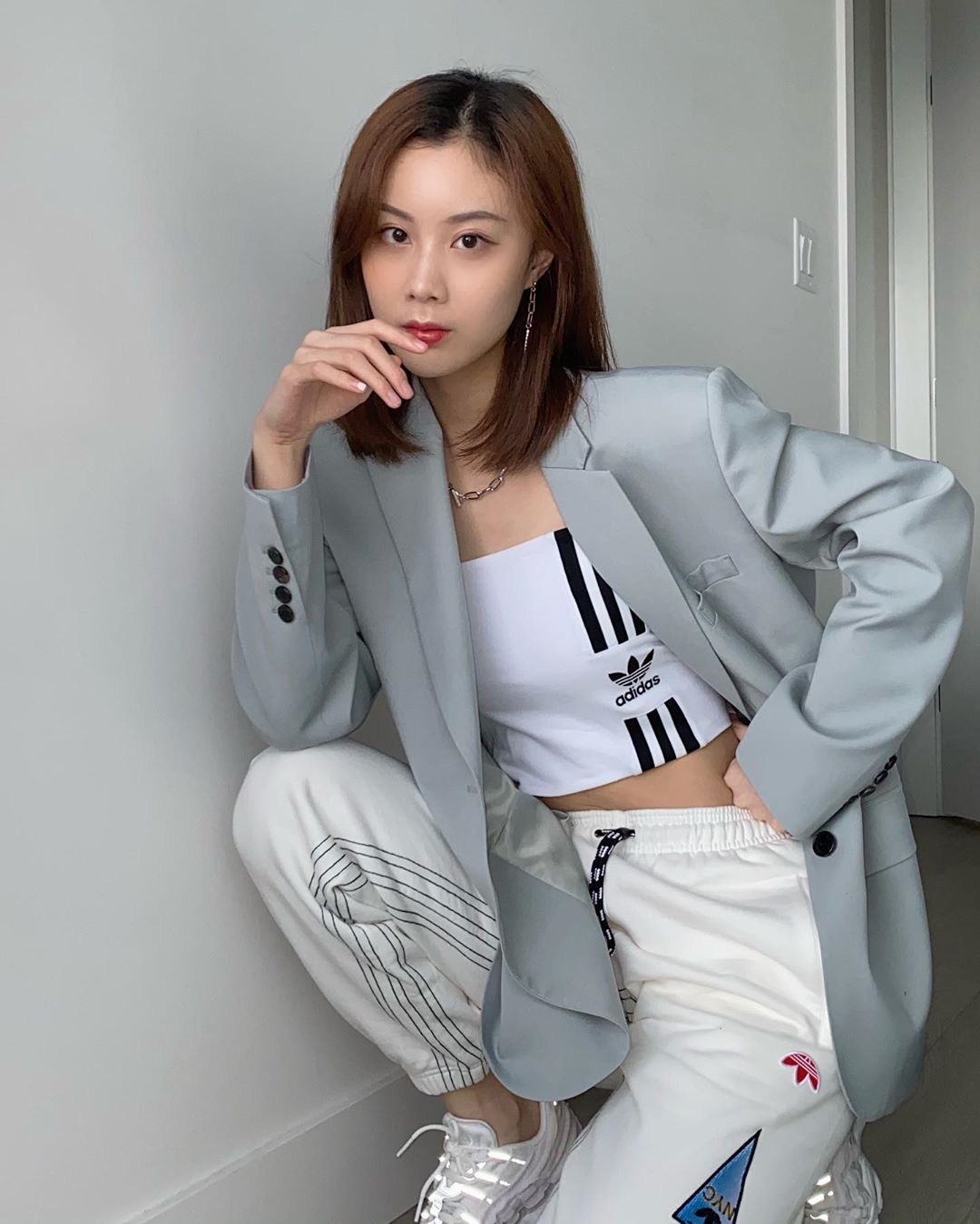 Quần jogger trắng phối cùng croptop và blazer xám