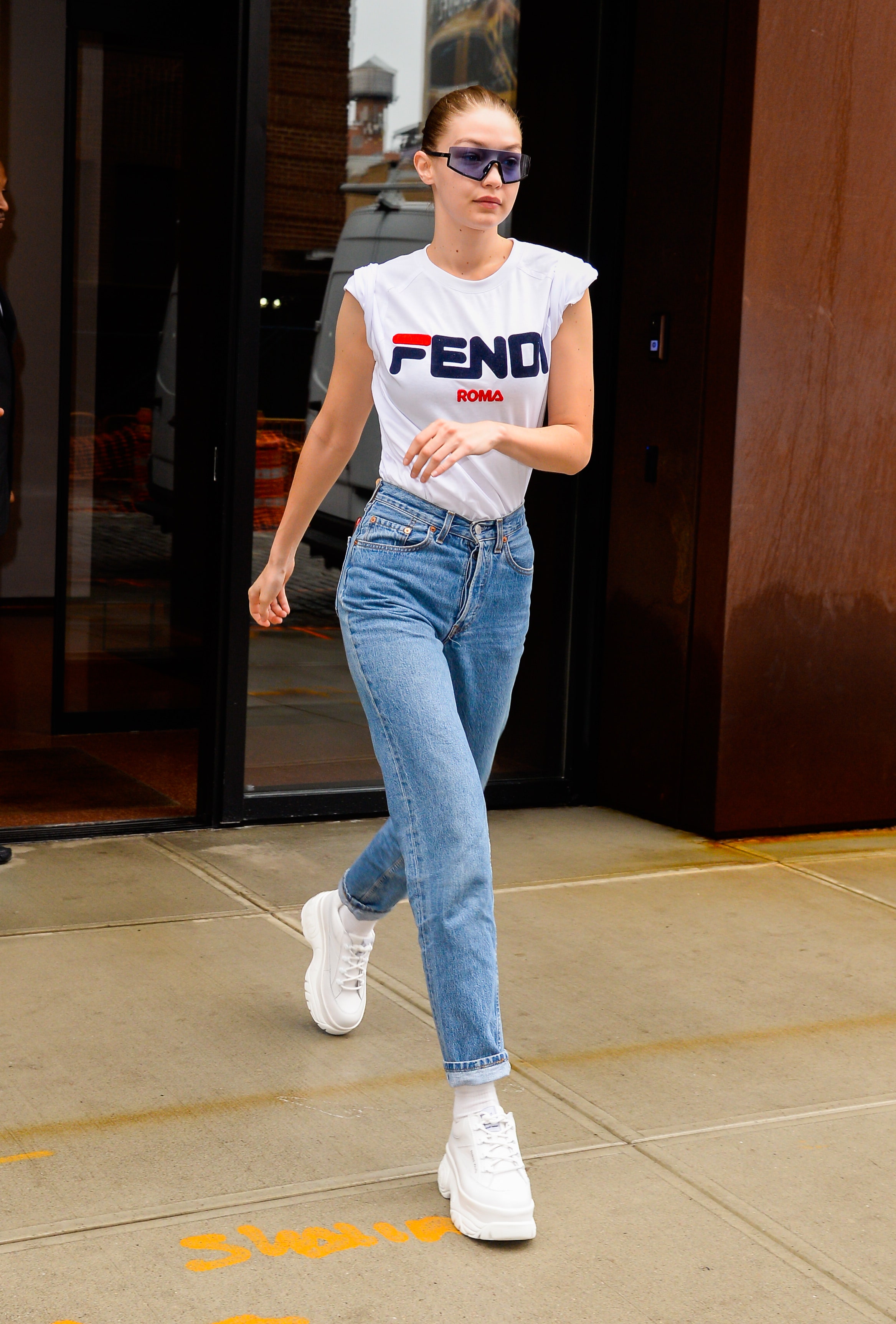 gigi hadid mặc áo thun độn vai quần jeans mang giày sneaker trắng