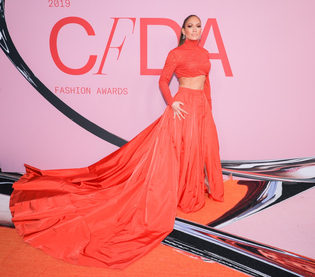 jennifer lopez mặc áo crop top chân váy màu cam tại lễ trao giải thời trang cfda 2019