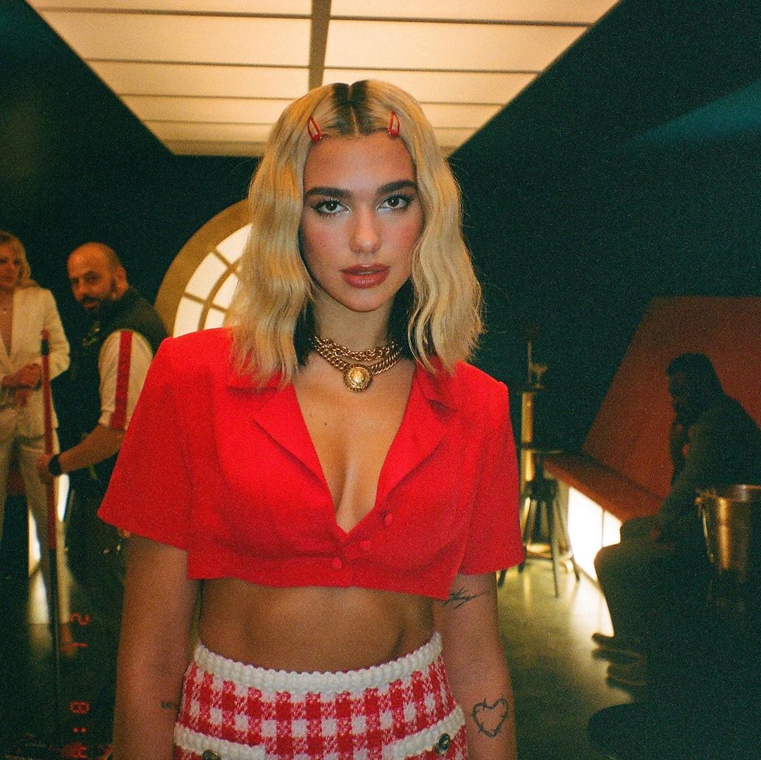 Dua Lipa đeo phụ kiện tóc kẹp nhựa màu đỏ