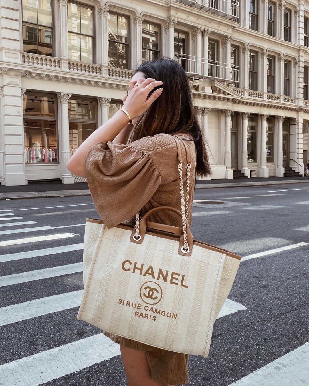 cô gái mặc váy nâu đeo túi xách oversize chanel