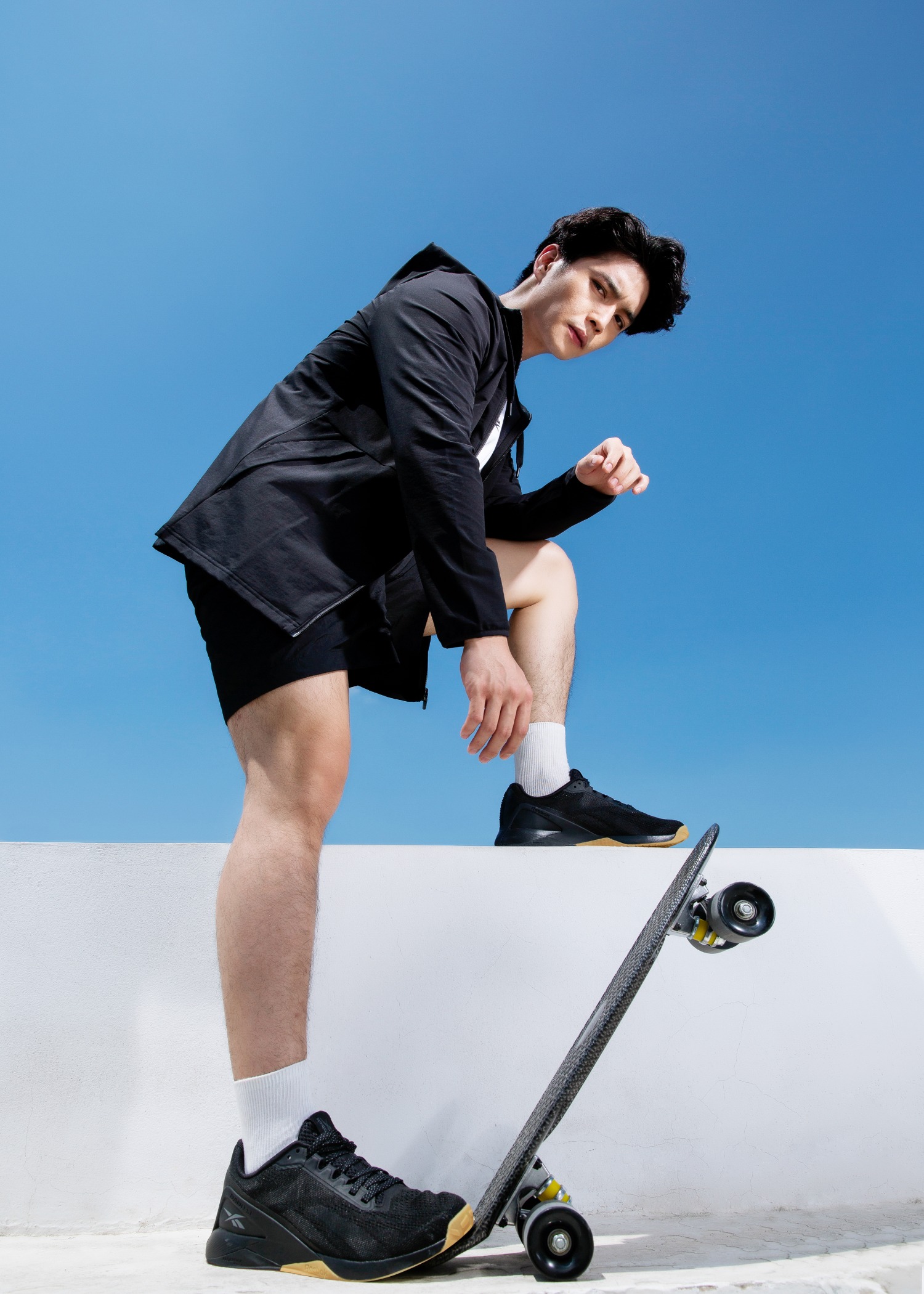Huy Tran in Reebok black jacket and skateboard