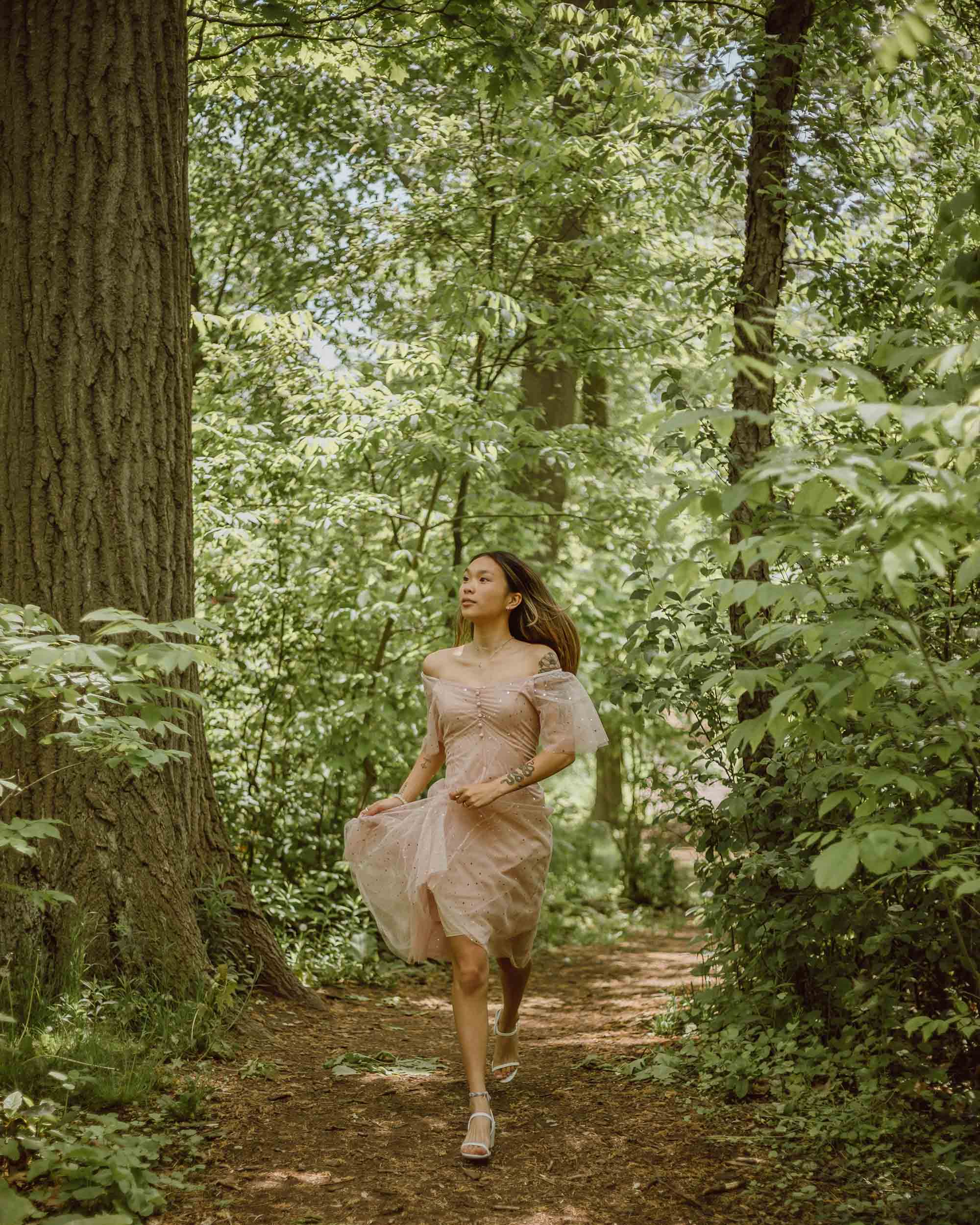 single girl running in the forest jasmin chew unsplash