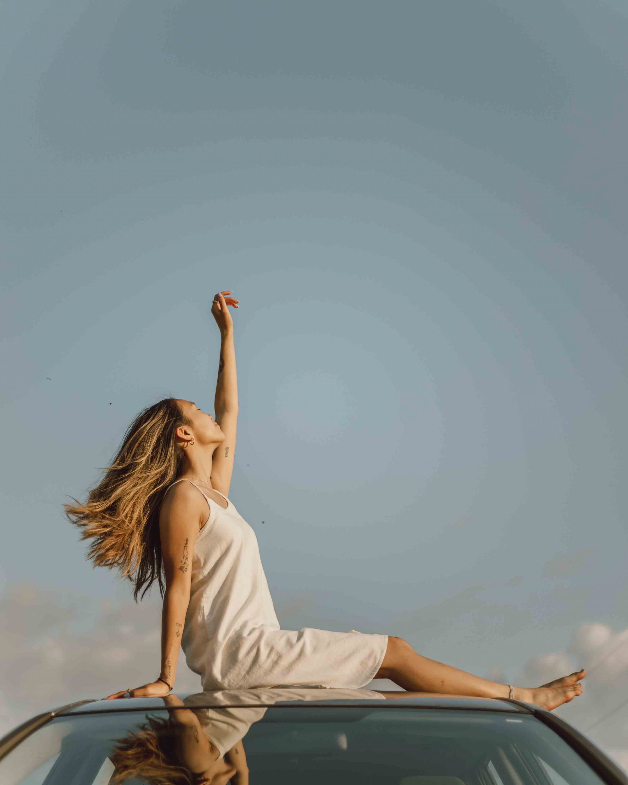 single girl sitting on top of car jasmin chew unsplash