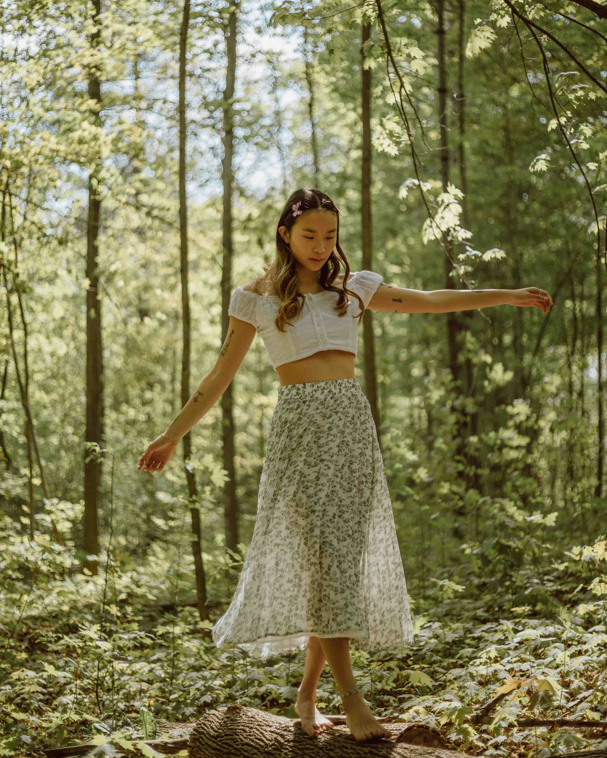 single girl playing in the woods jasmin chew unsplash