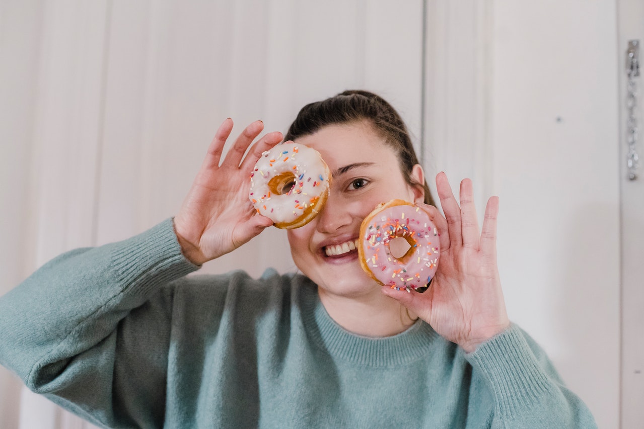 Cô gái cầm bánh donut tăng cân.