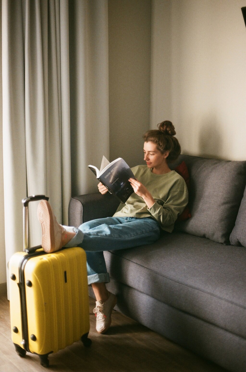 cô gái đọc sách bên vali du lịch 