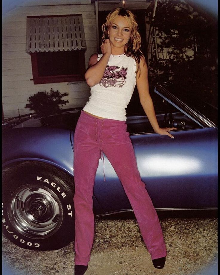 Britney Spears diện tank top trắng với quần jeans hồng pose trước xe đèn flash