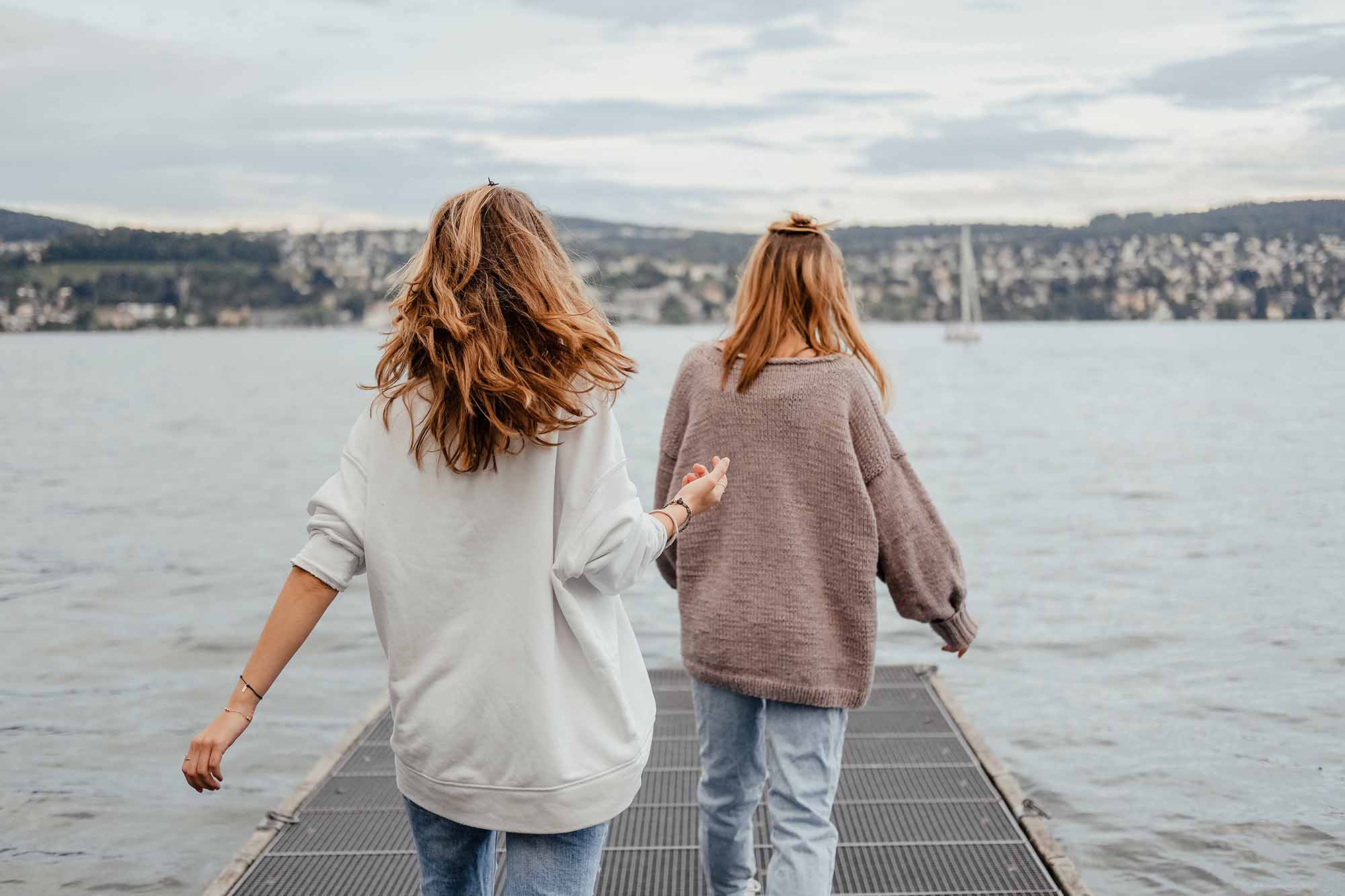hai cô gái dắt tay nhau đi trên biển