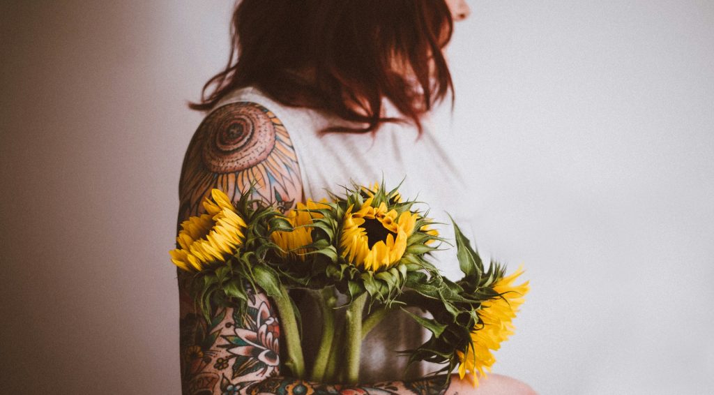 cô gái có hình xăm ôm hoa hướng dương