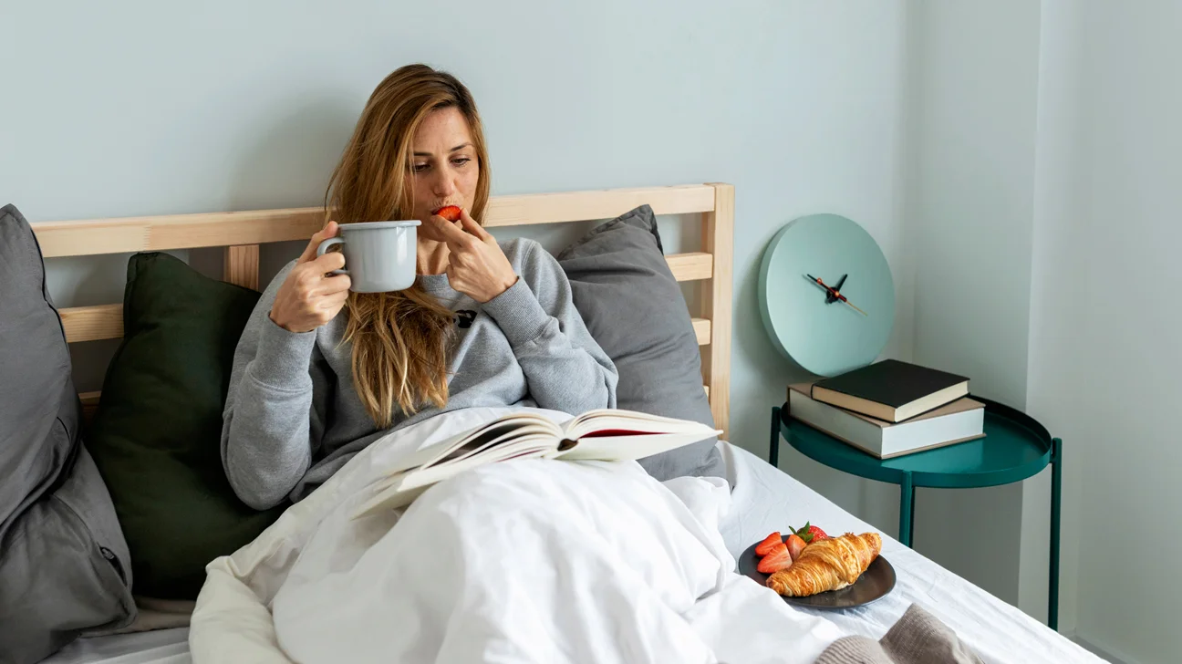 chế độ ăn 16/8 - cô gái ngồi ăn dâu trên giường