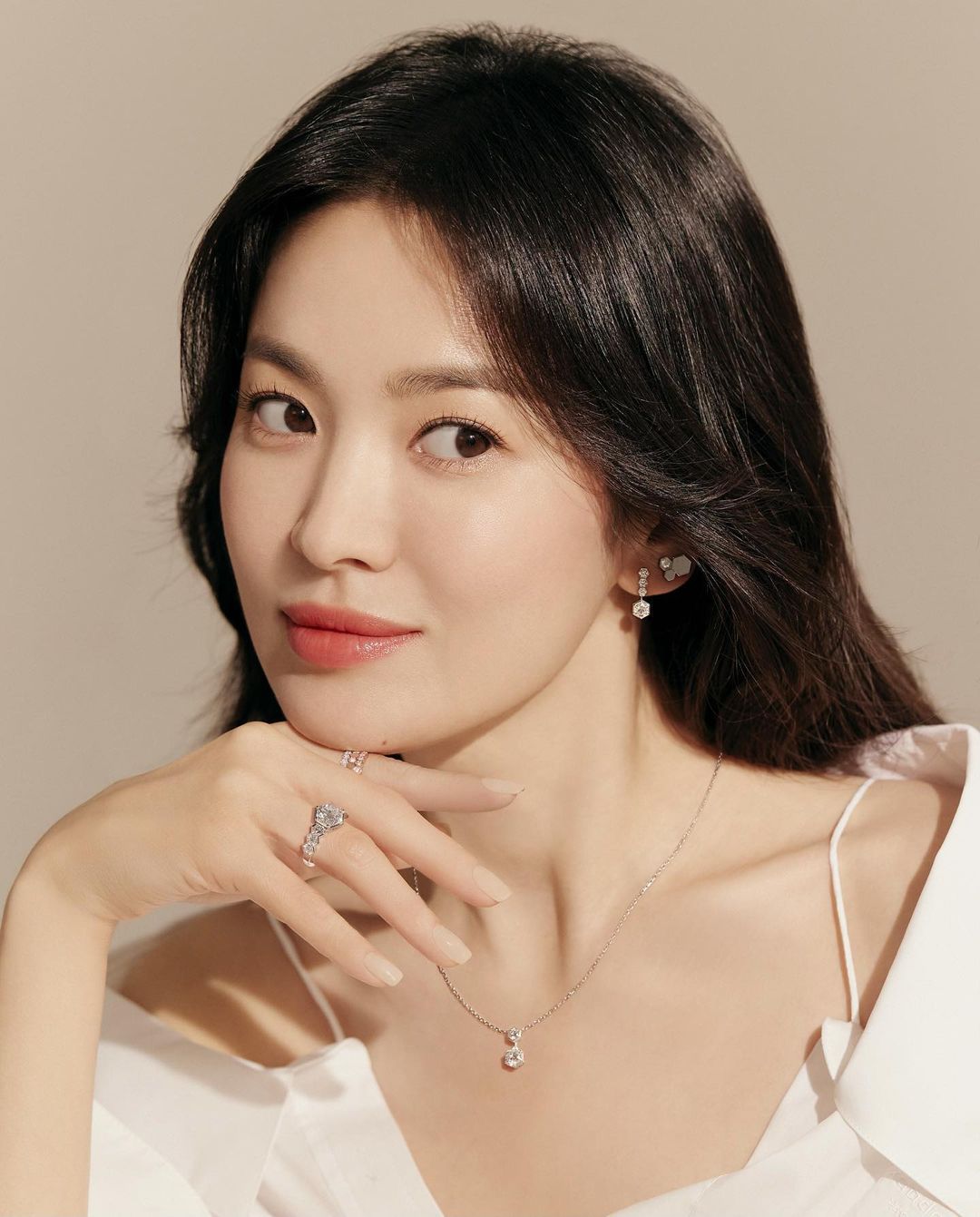 Song Hye Kyo cười chống tay lên cằm.