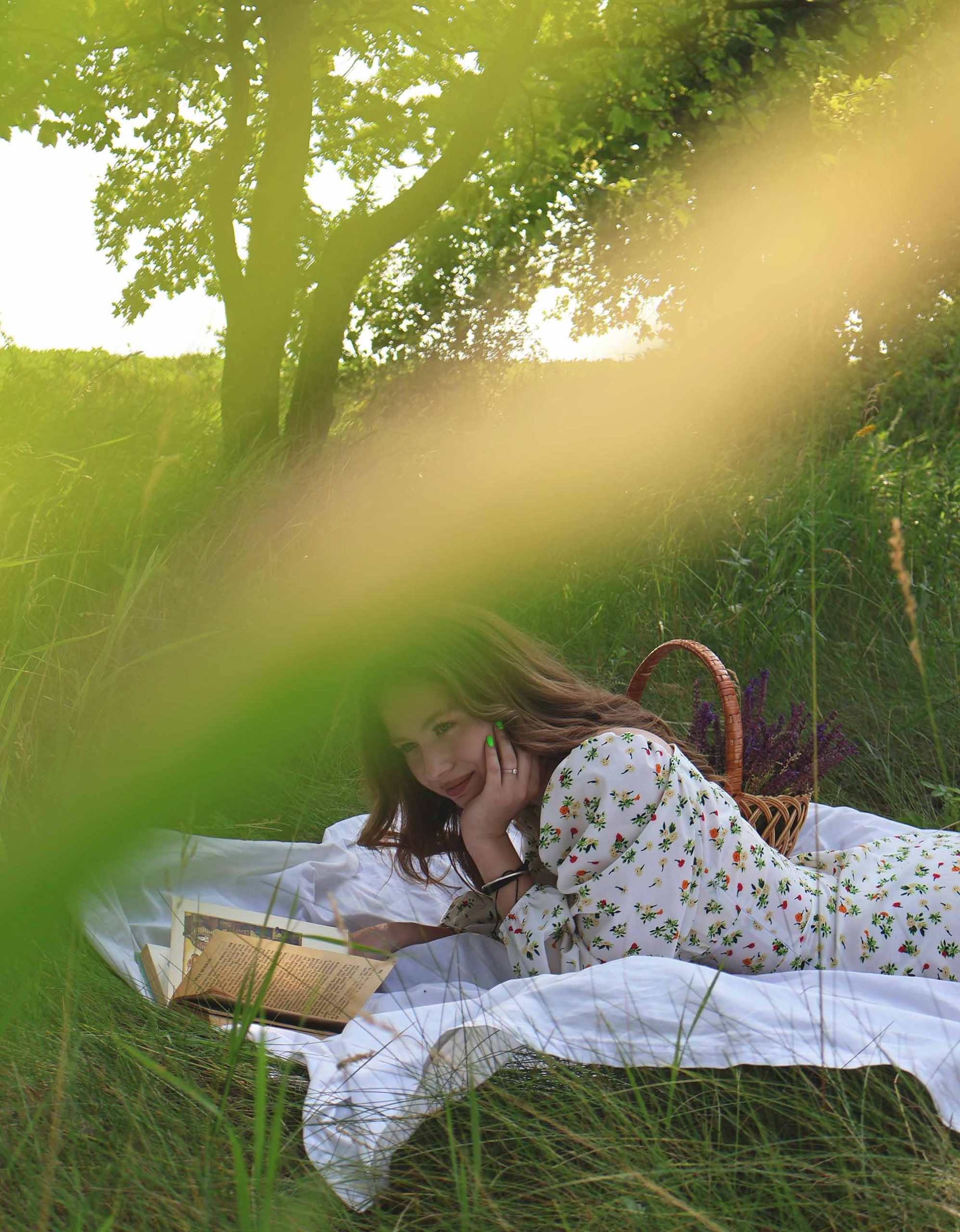cô gái nằm đọc sách trên bãi cỏ một cách hạnh phúc