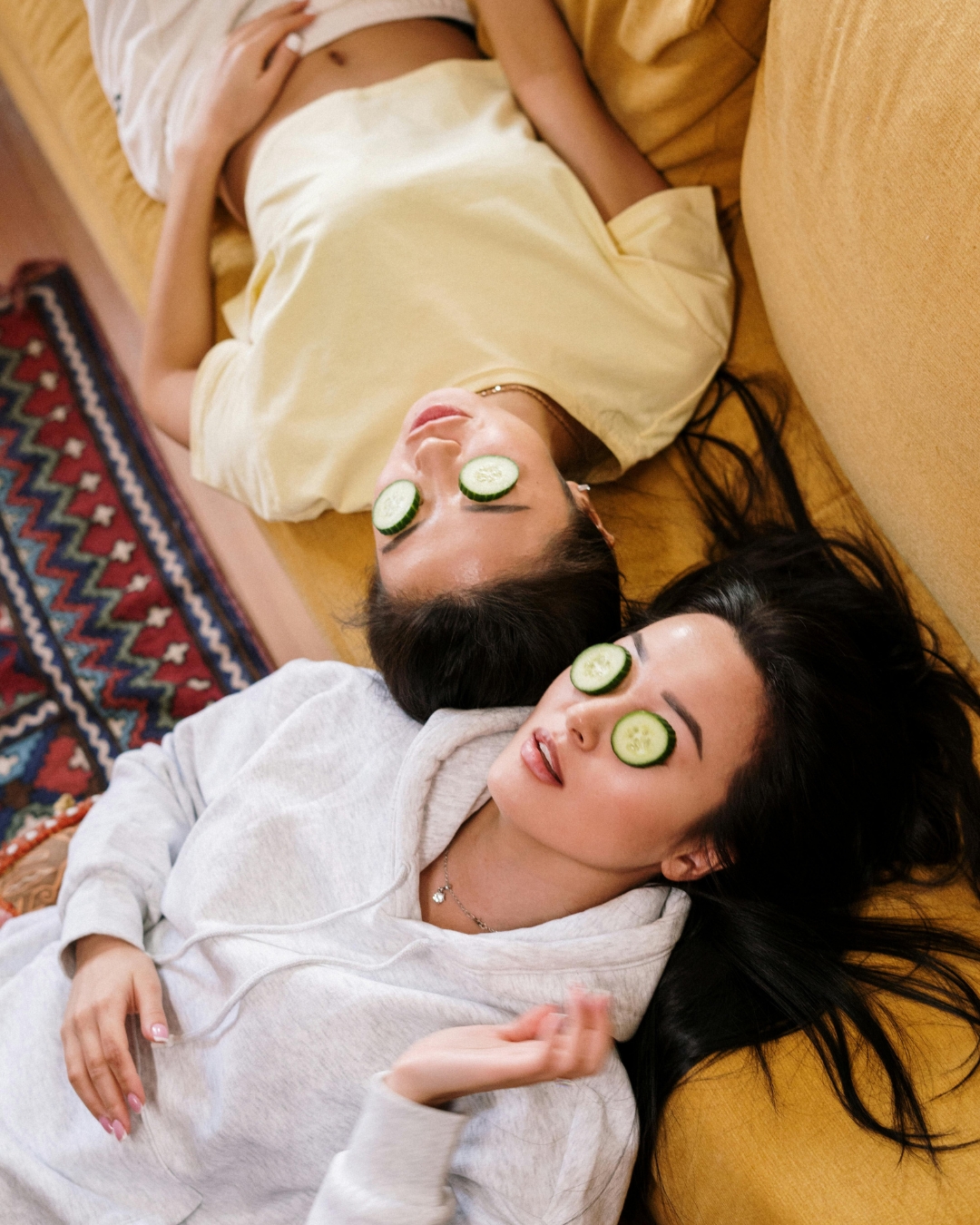 hai cô gái đắp dưa leo lên mắt để cải thiện quầng thâm mắt