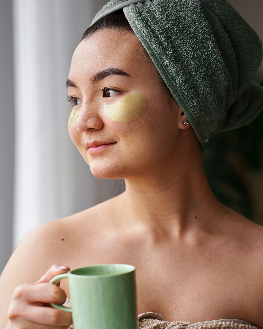 cô gái đắp mặt nạ giảm quầng thâm mắt và cầm ly nước