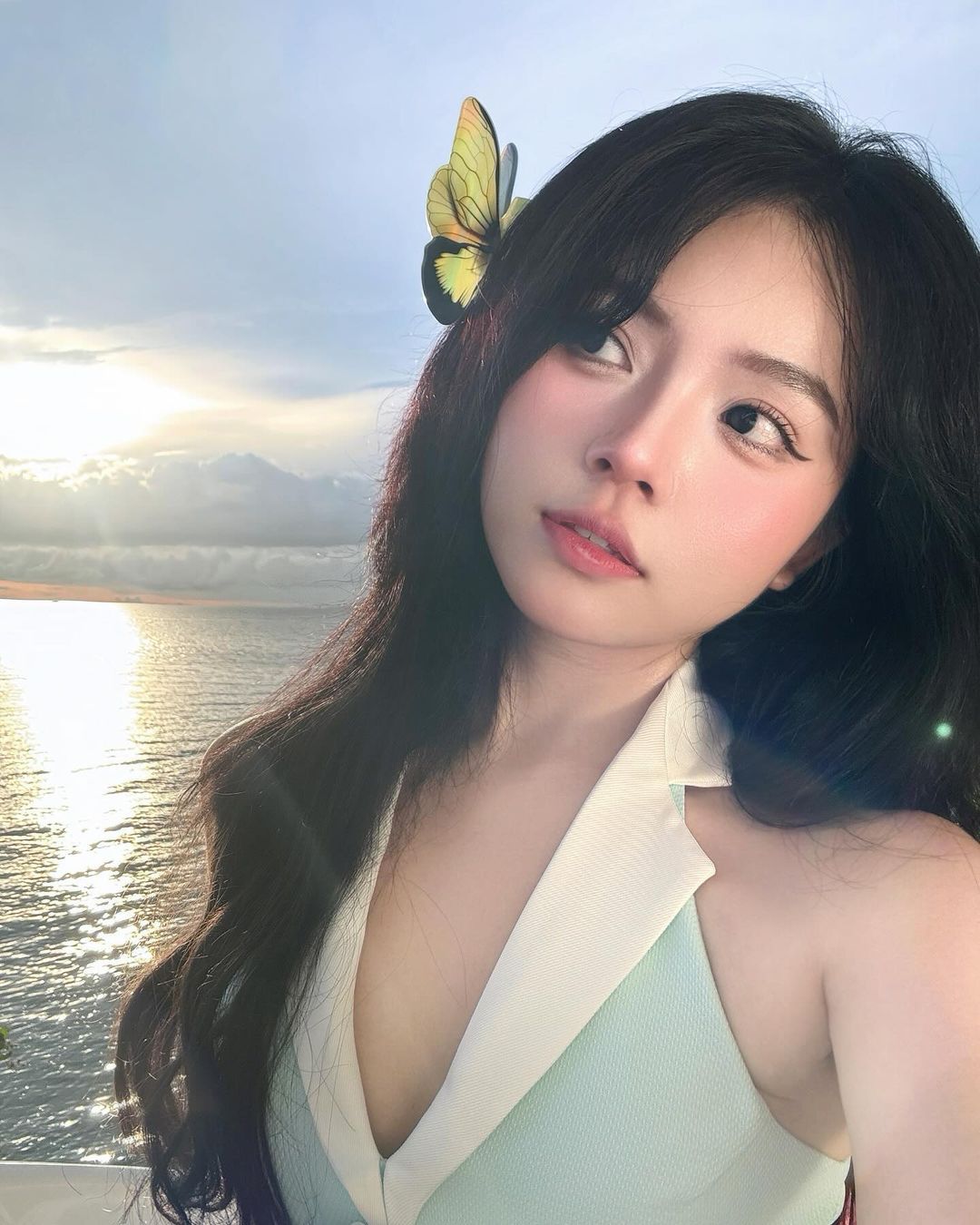 trang điểm - cô gái đánh son ombre và cài nơ hoa để chụp ảnh trên bãi biển